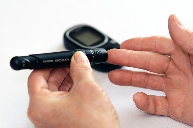 image showing a man testing blood glucose level